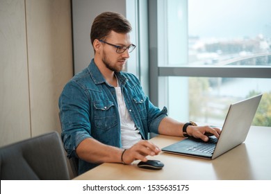 Ein junger Mann, der an einem Laptop arbeitet