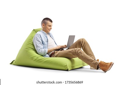 Young Man Working On A Laptop And Sitting On A Green Bean Bag Isolated On White Background