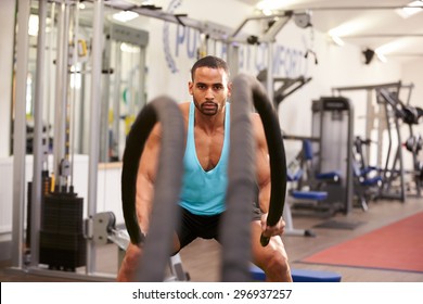 Young Man Working Out With Battle Ropes At A Gym