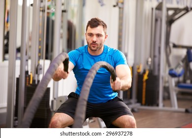 Young Man Working Out With Battle Ropes At A Gym