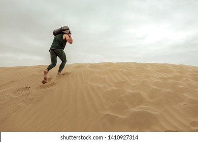 Young Man Working Out With A Sandbag In The Desert