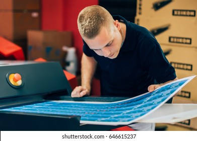 Young man working in printing factory. Printing Press