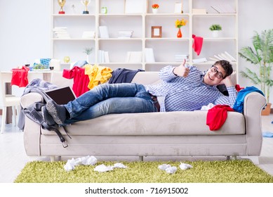 Young Man Working Studying In Messy Room