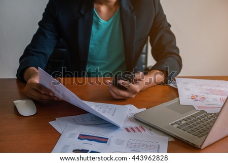 young man working using smartphone and notebook computer, Young man work and typing,financial work,workhard.