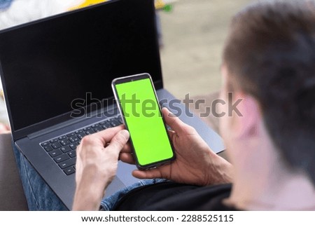 Young man works at home on a laptop. phone chromo key