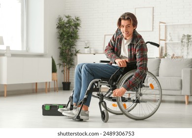 Young man with wrench repairing his wheelchair at home - Powered by Shutterstock