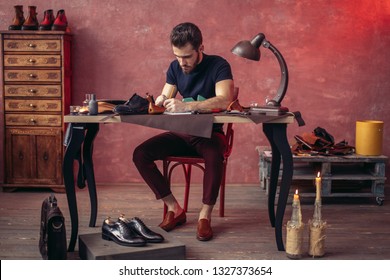 young man writing necessary information for repairing shoes, full length photo. man making up a draft at shoe shop - Powered by Shutterstock