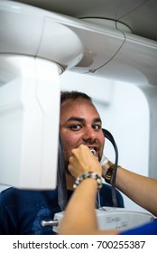 Young man at x ray machine in dentist clinic