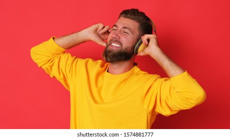 Young Man In Yellow Blouse Is Listening A Music.