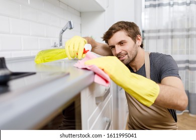 Young Man In Yellow Gloves Using Cleanser