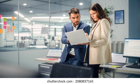 Young Manager Talking with Experienced Colleague while Using Laptop Computer in Office. Colleagues Discuss Business, Financial and Marketing Projects. Specialists Work in Diverse Team. - Shutterstock ID 2080837165