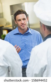 Young Manager Talking To The Staff Standing In A Kitchen