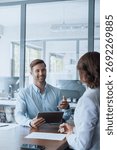 Young manager worker man talking with bank client in office. Business meeting entrepreneur people sitting at table, using gadget tablet device, discussing trade strategy or cv on interview. Vertical