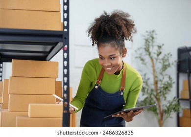 Young manager is working in a warehouse and checking inventory levels using a digital tablet. She is smiling and appears to be enjoying her work