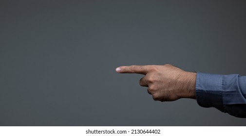 The young man's hand pointed to an empty copy space. isolated on black background copy space. Advertisement  presentation concept.
