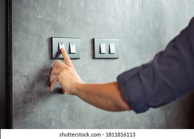 The young man's hand turned off the light switchEnergy saving concept - Shutterstock ID 1811816113