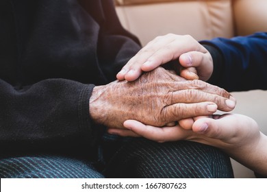Young man's holding older grandmother hands feel with love and support together, Care for elderly Helping hands, take care concept.