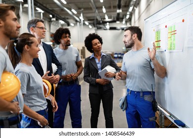 Young manual worker presenting new business strategy to company managers and his colleagues in a factory.  - Powered by Shutterstock