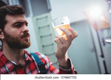 Young manufacturer holding beer glass at brewery - Powered by Shutterstock