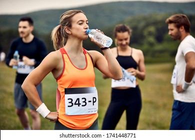 Young Marathon Runner Refreshing Herself With Water After The Race In Nature. 