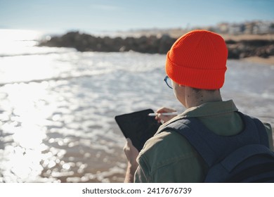 Young marine biologist analyzing sea water samples with an electronic tablet. Water quality tests. - Powered by Shutterstock