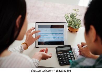 Young Married Couple Discussing Chart With Electric Energy Consumption And Paying Utility Bills