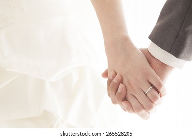 Young married couple holding hands, ceremony wedding day - Shutterstock ID 265528205