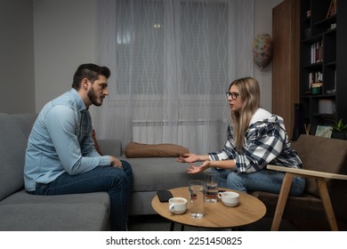 Young married couple husband and wife sitting at home having problems in their marriage and a cold relationship. A boyfriend and a girlfriend have an argument about spending too much money. - Powered by Shutterstock