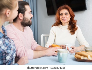 Young Married Couple And Senior Mother Having Bad Discussion 