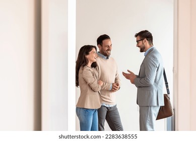 Young married couple talking with a real-estate agent visiting apartment for sale or for rent. Future parents buying an apartment. Real estate concept. A new beginning - Shutterstock ID 2283638555
