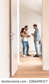Young married couple talking with a real-estate agent visiting apartment for sale or for rent. Future parents buying an apartment. Real estate concept. A new beginning - Shutterstock ID 2286698317