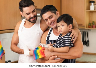 Young Married LGBT Couples Celebrate A Romantic Moment Together With Adopted Child To Become Parents With LGBT Flag