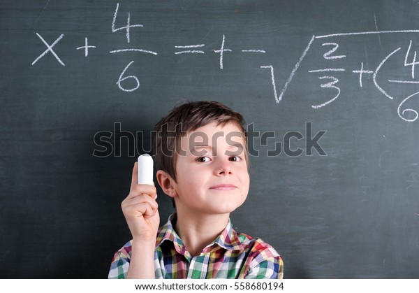Young math genius in front of\
blackboard with mathematical problem and chalk in his\
hand