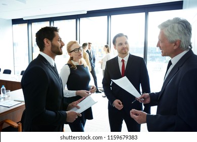Young and mature politicians in formalwear discussing points of their reports and consulting about ideas - Shutterstock ID 1159679383