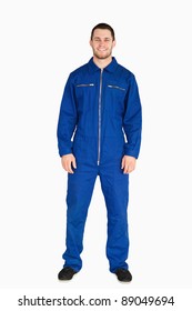 Young mechanic in boiler suit against a white background