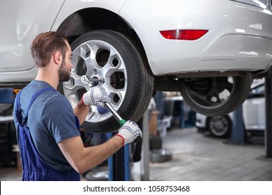 Young Mechanic Changing Wheel At Tire Service