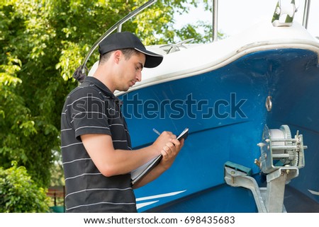 a young mechanic checking the motor boat