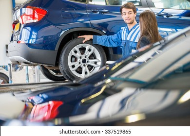 Young mechanic discussing with female customer while standing by car in garage - Powered by Shutterstock