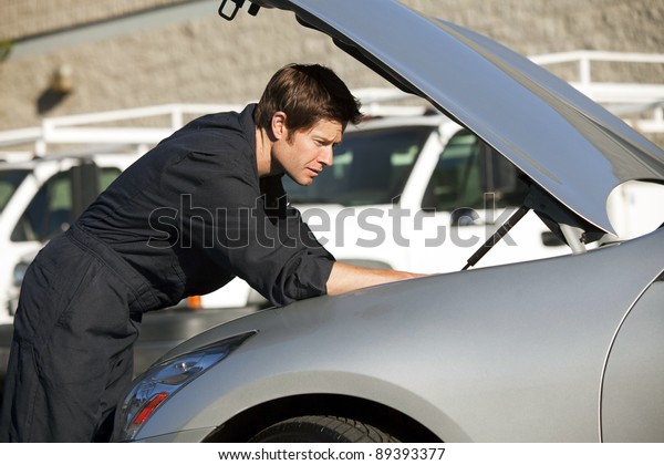 Young mechanic fixing a\
car