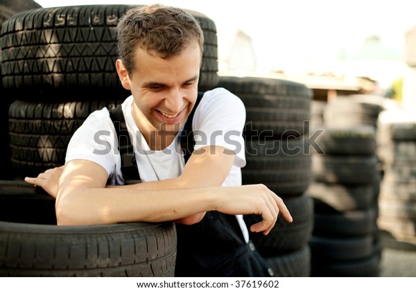 Young mechanic\
laughing outside car\
service