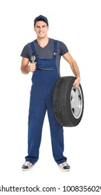 Young Mechanic In Uniform With Car Tire On White Background