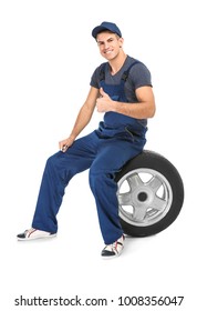 Young Mechanic In Uniform With Car Tire On White Background