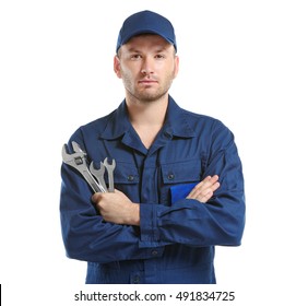 Young Mechanic In Uniform With Crossed Arms And Wrenches Standing, Isolated On White