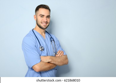 Young Medical Assistant With Stethoscope On Color Background