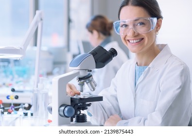 Young medical student doing research in the clinical lab, she is smiling and looking at camera - Powered by Shutterstock