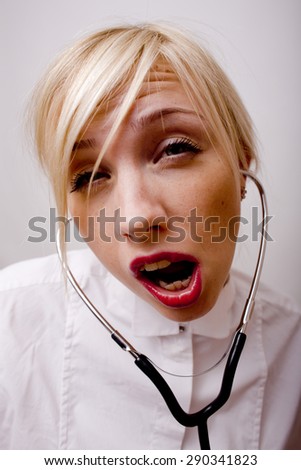 young medical student with stethoscope silly face close up on white