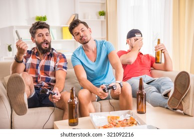 Young Men Drink Beer, Eat Pizza And Play Games Play Station