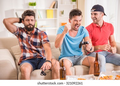 Young Men Drink Beer, Eat Pizza And Play Games Play Station