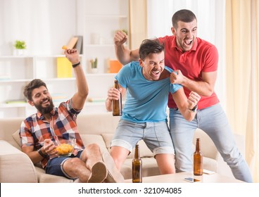 Young men drink beer, eat pizza and cheering for football - Powered by Shutterstock