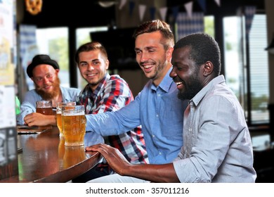 Young Men Drinking Beer In Pub